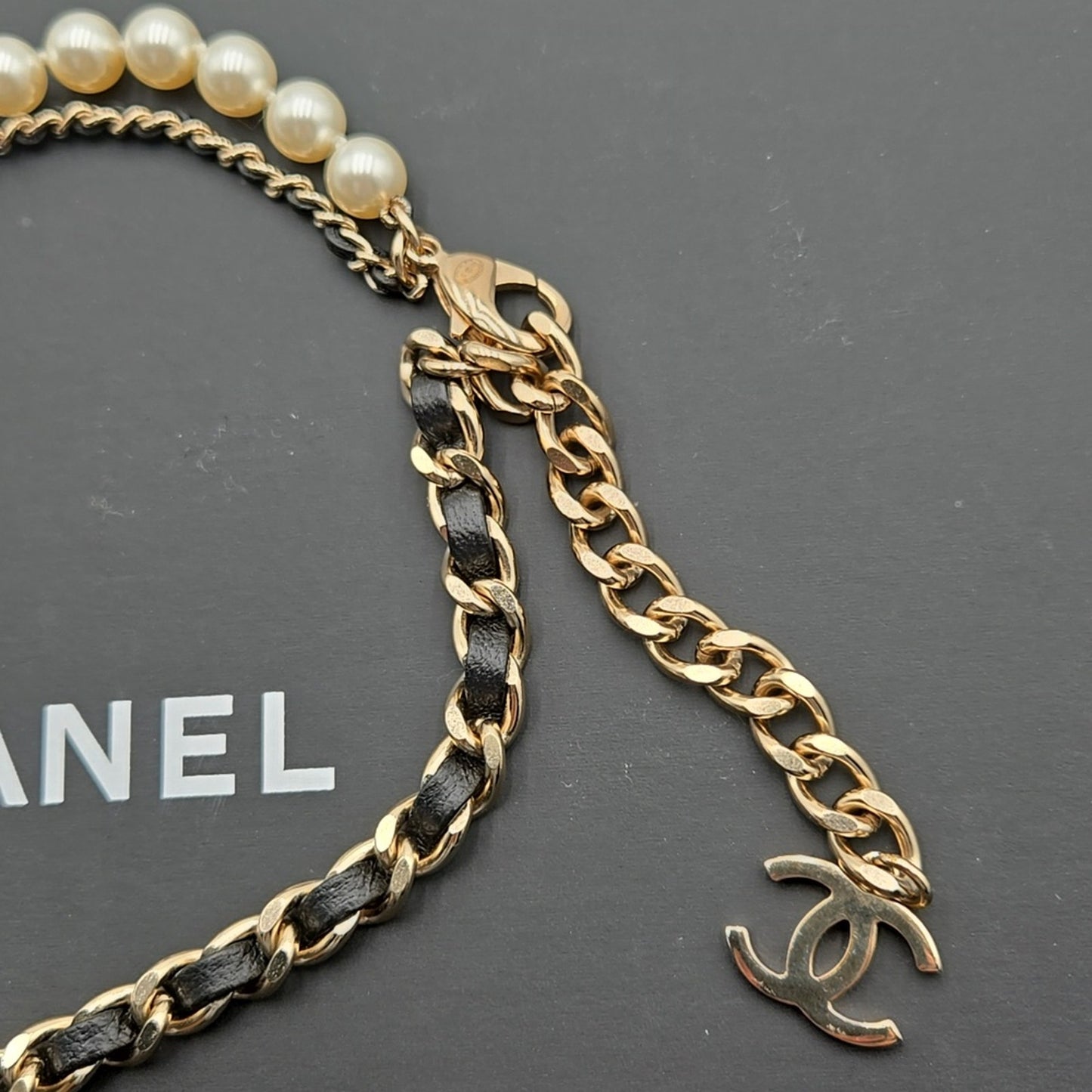 #112 Chanel Coco Mark, Matelasse Bag Motif, Faux Pearl, and Leather - B21SAB6125