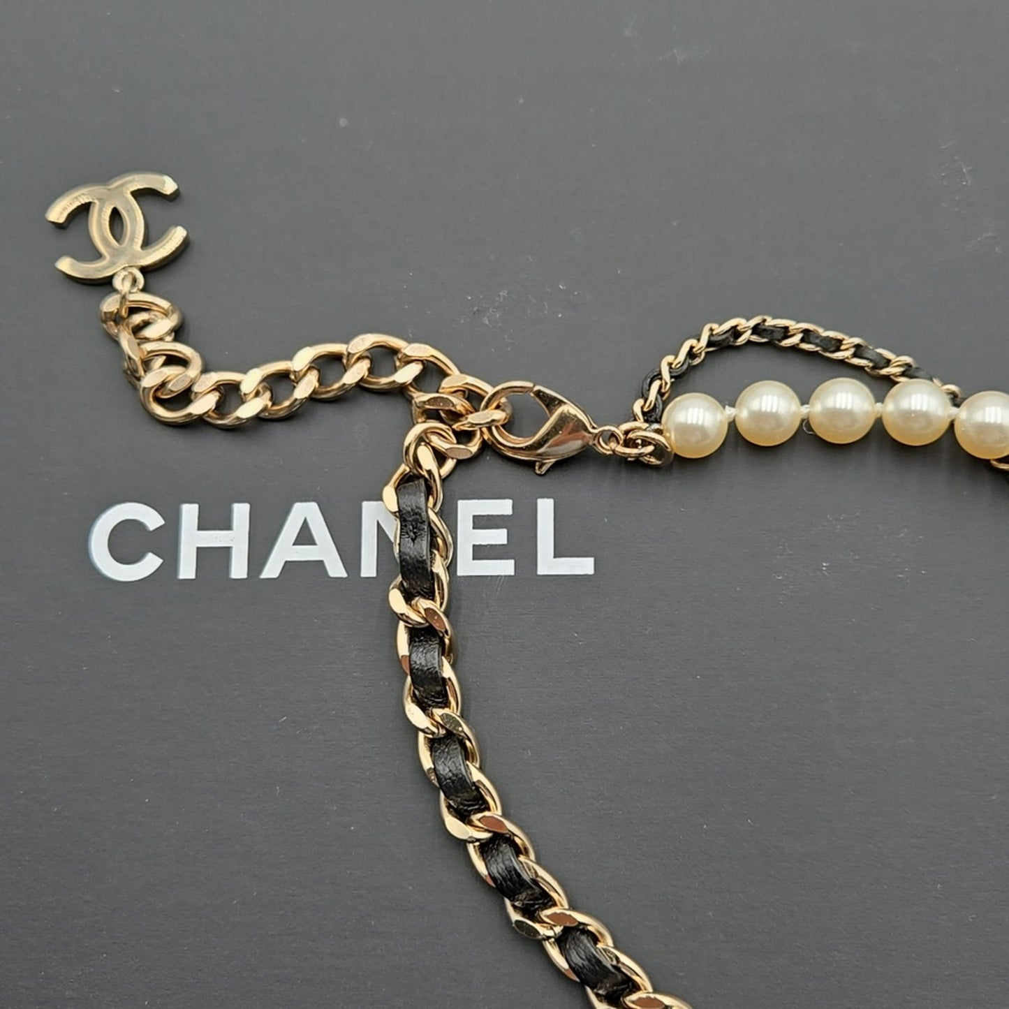 #112 Chanel Coco Mark, Matelasse Bag Motif, Faux Pearl, and Leather - B21SAB6125