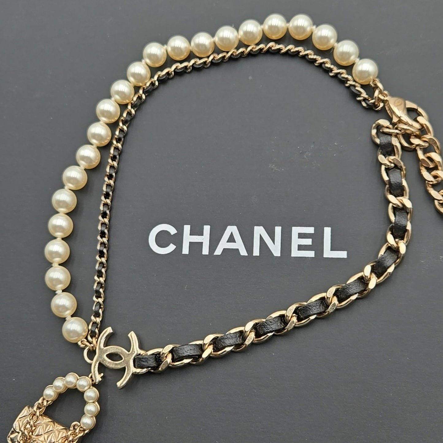 #112 Chanel Coco Mark, Matelasse Bag Motif, Faux Pearl, and Leather - B21SAB6125